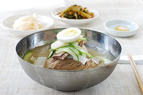 Mì lạnh Naengmyeon là món được chế biến từ kiều mạch, khi dùng du khách sẽ trộn mì với tương ớt, ăn cùng với trứng luộc, thịt bò thái, dưa chuột. Ảnh: Korean Bapsang.